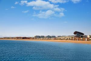 赫尔格达Rixos Premium Magawish Suites and Villas- Ultra All-Inclusive的享有海滩、建筑和大海的景色