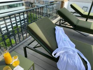 塞维利亚Aquitania Home Suites的阳台上的椅子和桌子,备有橙汁