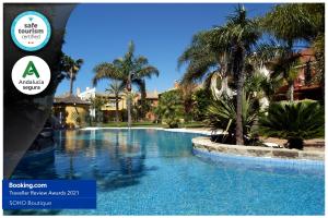 圣玛丽亚港Apartamentos Soho Boutique Vistahermosa的棕榈树度假村的游泳池
