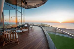 赫尔格达Rixos Premium Magawish Suites and Villas- Ultra All-Inclusive的游轮上带桌椅的阳台