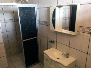 马沙蒂纽Vyalle Hotel的一间带水槽、镜子和淋浴的浴室