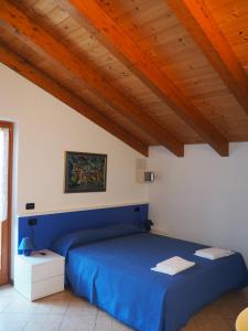 滕诺Residenza Arcobaleno的一间卧室设有蓝色的床和木制天花板