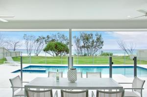 黄金海岸圣淘沙图根酒店 - 海滨5卧室的一间带桌子和游泳池的用餐室
