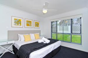 黄金海岸圣淘沙图根酒店 - 海滨5卧室的一间卧室设有一张大床和一个窗户。