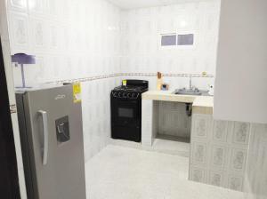 里奥阿查Apartamentos Riohacha的厨房配有炉灶和冰箱。