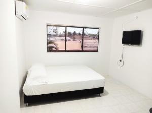 里奥阿查Apartamentos Riohacha的白色的客房设有床和窗户。