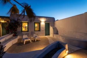 凯勒里瓦迪Cycladic Luxury and Comfort in Kalo Livadi的后院庭院配有白色椅子和房屋