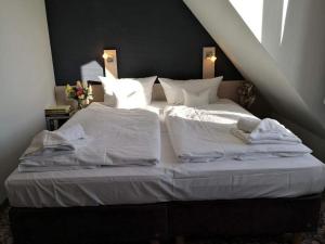 施托尔佩奥夫乌塞多姆Die Remise Bayard RE-12的一张白色大床,配有白色床单和枕头
