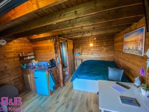 厄伊特海斯特Chalet - B&B de Koog的小木屋内的卧室配有一张床和水槽
