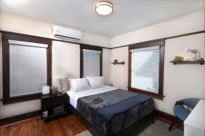 圣地亚哥Fern House South Park Craftsman的一间卧室设有床、两个窗户和一张沙发