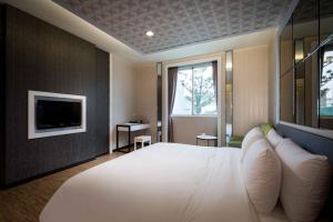 梧栖爱力根汽车旅馆的卧室配有一张白色大床和电视。