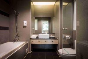 梧栖爱力根汽车旅馆的一间带水槽、浴缸和卫生间的浴室