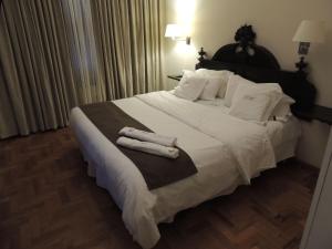 拉里奥哈GM Rooms Rental Suites的卧室配有带毛巾的大型白色床