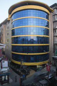 大吉岭Jai Hotels的一座黄色的大型玻璃建筑