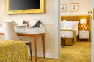斯普利特Hotel Villa Harmony的一间卧室配有一张桌子和一张带电视的床。