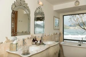 豪特湾大西洋亭茨瓦罗酒店的一间带两个盥洗盆、浴缸和窗户的浴室