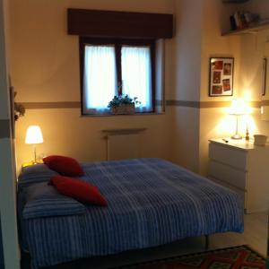 列尔纳勒奥尔滕赛拉格迪科莫住宿加早餐旅馆的一间卧室配有一张带红色枕头的床和一扇窗户