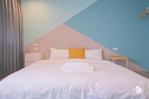 高雄秧秧微旅 Jezreel Inn的卧室配有白色床和条纹天花板
