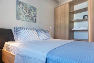 科斯镇"NISSI BEACH" Houses的一间卧室配有一张带蓝色棉被的床