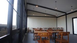 雅加达DJURAGAN KAMAR SLIPI的用餐室设有桌椅和窗户。