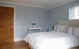 BickleyMoss Cottage的卧室配有白色的床和木门