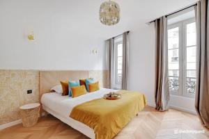 巴黎CMG Résidence République II - Rue Béranger的一间卧室配有一张带黄色毯子的大床