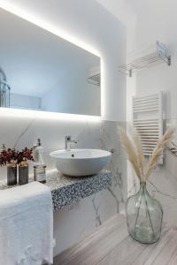 加提欧马里Romagna Suite Hotel的白色的浴室,配有水槽和花瓶