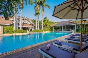 素可泰LE CHARME 素可泰度假酒店的一个带躺椅和遮阳伞的游泳池