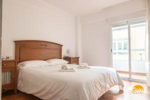 加的斯Villa Lola by Cadiz Time的一间卧室配有一张带白色床单的床和一扇窗户。