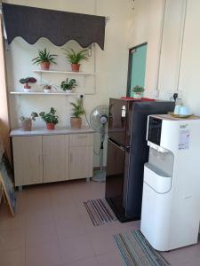 瓜拉勿述Aban Transit House的厨房配有冰箱和架子上的盆栽植物