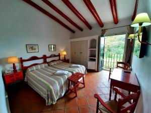 阿拉色那Finca Valbono Apartamentos Rurales y Hotel的一间卧室配有一张床、一张桌子和一张桌子