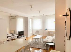 贝尔格莱德缪阿丽娜公寓的白色的客厅配有桌子和电视。