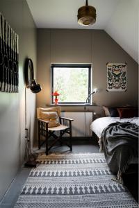 FlateyriSolbakki的卧室配有床、椅子和窗户。