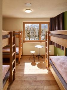沙恩沙恩-瓦杜兹青年旅舍的客房设有三张双层床和一扇窗户。