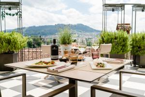 伯尔尼伯尔尼贝耶乌尔宫酒店的阳台上摆放着一盘食物和葡萄酒的桌子