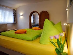 施卢赫湖Wochner's Hotel-Sternen Am Schluchsee Hochschwarzwald的一间卧室配有带鲜花的绿色床