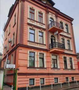 索非亚KM!Sofia - Стаи за гости的一座橙色的建筑,旁边设有阳台