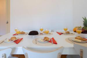 波尔图Spacious Comfortable Apartment - Balcony的餐桌,带食物盘和橙汁杯