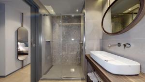 米兰GALLERIA The Smart Boutique APARTHOTEL By OSPITAMI的带淋浴、盥洗盆和镜子的浴室