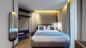 米兰GALLERIA The Smart Boutique APARTHOTEL By OSPITAMI的一间卧室配有一张带白色床单和蓝色枕头的大床。