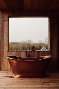 阿斯隆Glasson LakeHouse的窗户客房内的木制浴缸