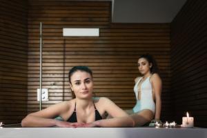 加埃塔米拉索尔国际酒店的两个女人坐在镜子前的浴缸里