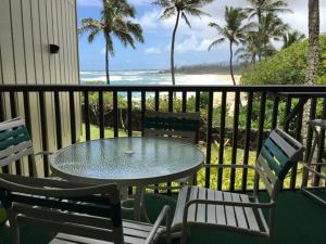 卡帕阿Wailua Bay View Resort的海滩阳台的桌椅