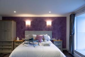 普里茅斯The Three Crowns B&B的一间卧室配有一张大床和紫色墙壁