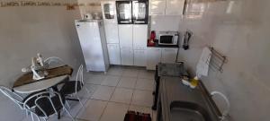 保利斯塔Ap07-A 50 Metros da Praia Flats Completamente Mobiliados的一间带水槽和冰箱的小厨房