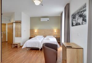 奥莱希尼察Nocleg EM的卧室配有1张床、1张桌子和1把椅子
