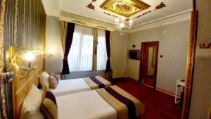 伊斯坦布尔巴克栝塔山商务机场酒店的酒店客房设有两张床和吊灯。