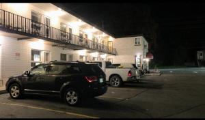 帕里桑德Sunrise Inn的停在大楼前停车场的汽车