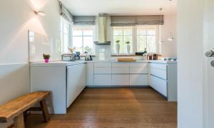 维克Freischwimmer的厨房配有白色橱柜和木板凳