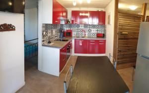 Le LambertAu ti bonheur d'en O '的厨房配有红色橱柜和木桌